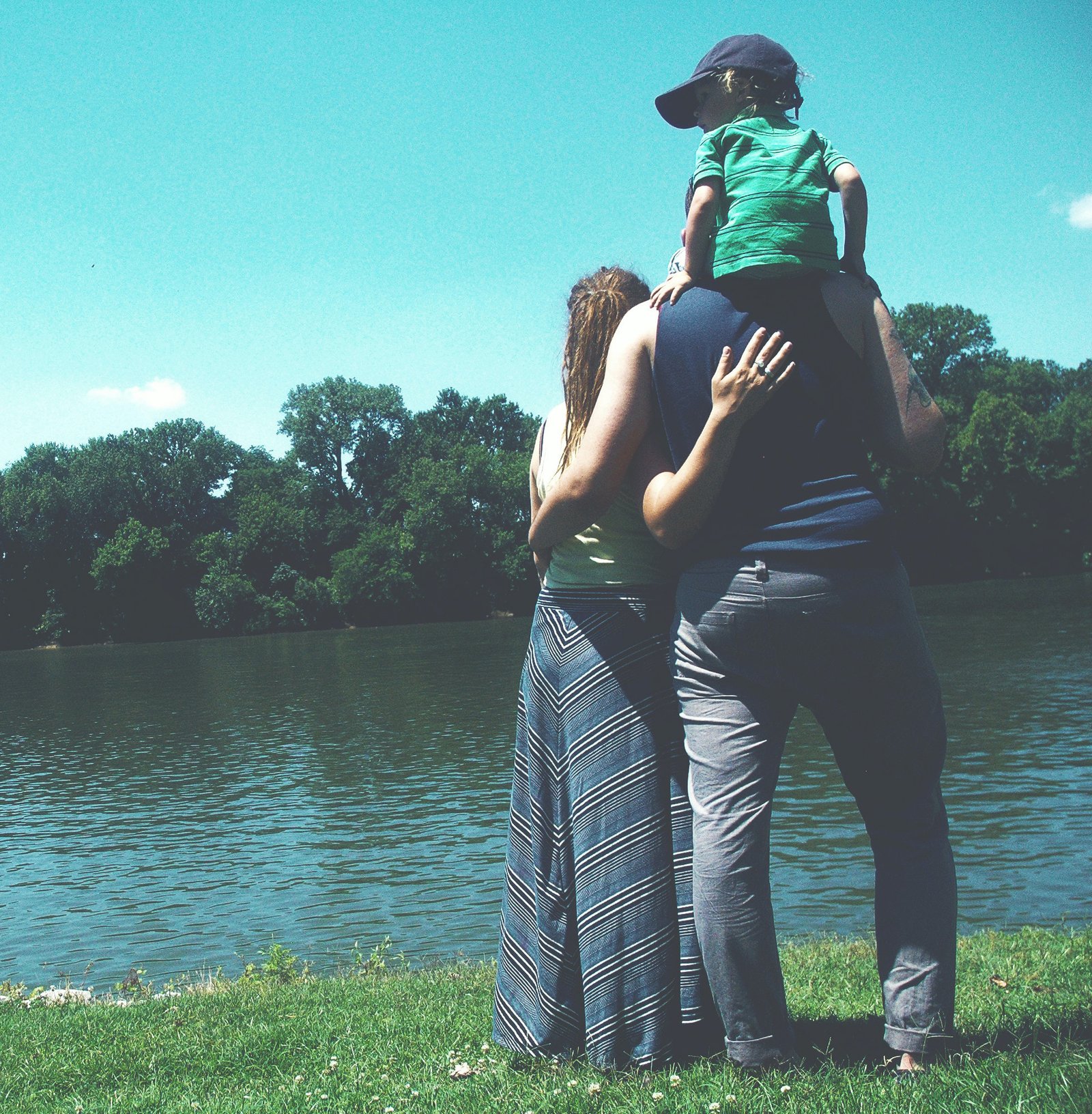 Family standing in front of a lake looking at the horizon.